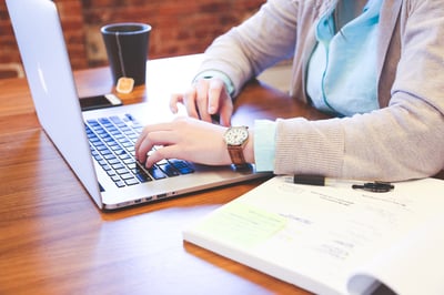 woman sitting at desk typing on computer